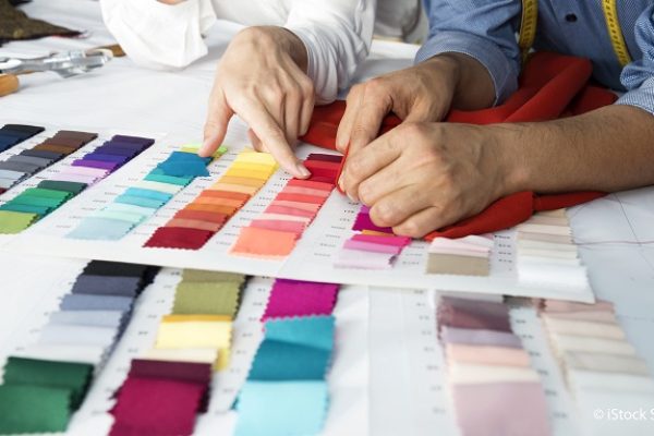 Fashion designers are choosing fabric and color for their new collection.